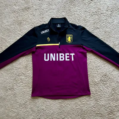 Front view of Aston Villa 2018/19 Luke 1977 Track 1/4 Zip Jacket (Unibet) - Men's Medium